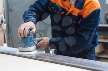 Furniture production or craft concept: worker polishing the stone surface of furniture part with polish machine