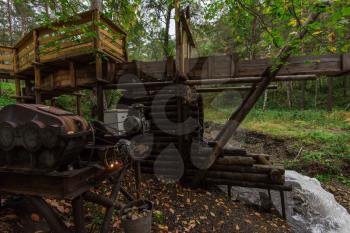 Rustic watermill with wheel being turned by force of falling water from Altai mountain river. Short shutter speed.