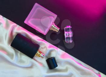 Flat lay composition with two perfume bottles on cloth background