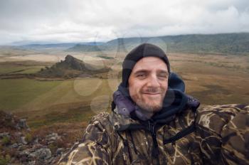 Caucasian man in the mountain making selfie on background nature landscape