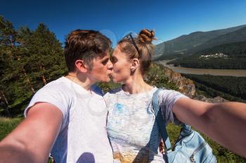 Kissing man and woman on top mountain in Altai