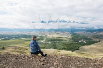 Man watching to glacier in Altai mountains. Resting in mountains or global warming concept