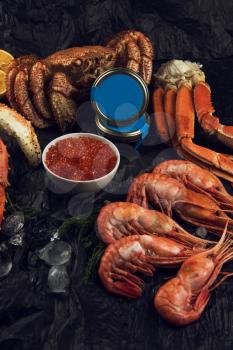 Set of fresh seafood: red and black caviar, limb of hairy crab, limb of snow crab, far eastern kamchatka crab