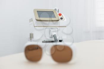 Protective glasses on laser epilation equipment in spa center. Hair removal cosmetology concept.