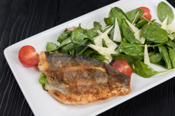 Grilled Dorado fish fillet with spinach, tomato and cheese