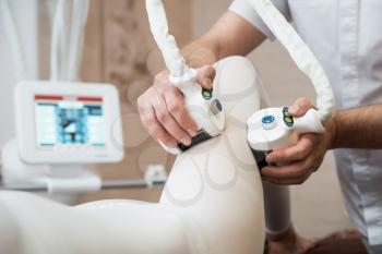 Procedure laser lipolysis of the woman hips in a beauty center.