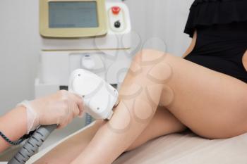 Laser epilation of legs, hair removal cosmetology procedure. Health and beauty concept.