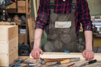 Carpenter working with a chisel and hammer in a wooden workshop
