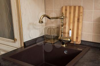 Photo of new modern kitchen interior. Luxury gold water tap