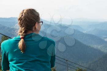 Woman standing and looking into the distance in mountains
