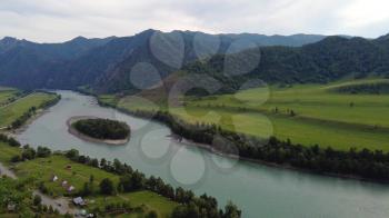 Aerial Time lapse of Mountain river Katun and green egg shaped island into the river, green valley, beauty summer evening, Altai mountains