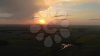 Aerial view from high attitude of sunshine dramatic sky. Sunset scenic sky above summer field and meadow in evening. Hyperlapse