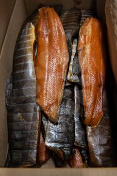 Smoked fish in craft paper box. Ready for delivery production. Smoked fish production concept