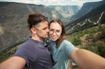 Loving couple together on Katu Yaryk mountain pass and the valley of the river of Chulyshman, Altai mountains, beauty summer day landcape. Travel, leisure and freedom concept