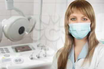 Female ophthalmologist in protective mask and whitecoat