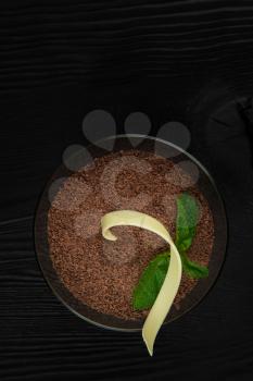Delicious Italian dessert tiramisu, on a black wooden background decorated with mint leaf. Top view with copy space.