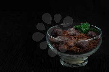 Chocolate dessert of cookies with pieces of chocolate and mint on a dark wooden background.