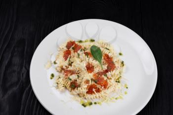 Pasta with red caviar parmesan cheese and basil. The concept of Italian cuisine.