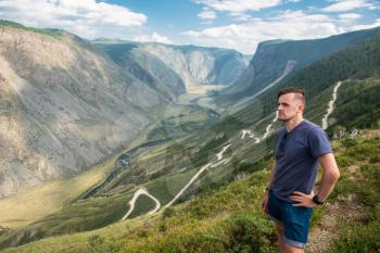 Man on the top of Altai mountain, Katu Yaryk mountain pass and the valley of the river of Chulyshman, beauty summer day landcape. Travel, leisure and freedom concept
