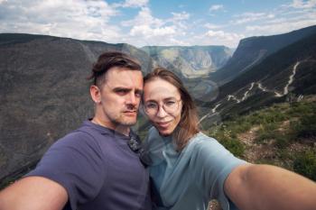 Couple selfie on the top of Altai mountain, Katu Yaryk mountain pass and the valley of the river of Chulyshman, beauty summer day landcape. Travel, leisure and freedom concept
