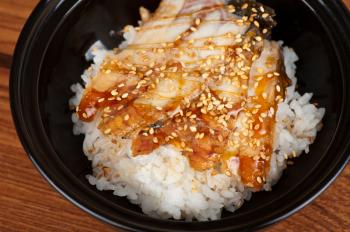 Japanese cuisine, eel with rice at black plate