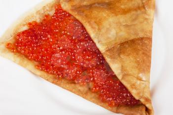 Pancake with red caviar closeup photo