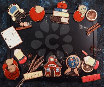 Back to school concept made with gingerbreads cookies on a blackboard background with copyspace