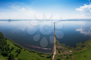 Beryozovskoye reservoir - cooling reservoir of Beryozovskaya GRES. Aerial drone view of lake landscape with road in sunny summer. Berezovskaya GRES is a thermal power plant in the town of Sharypovo, Krasnoyarsk Territory of Russia.