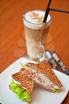 Sandwich with cheese and salmon and vegetables with latte