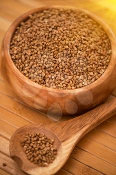 buckwheat at wooden plate on wooden background
