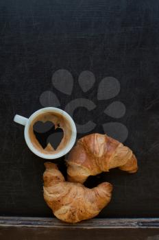 coffee with hearts and croissant at board
