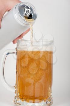 beer is pouring into glass on white background