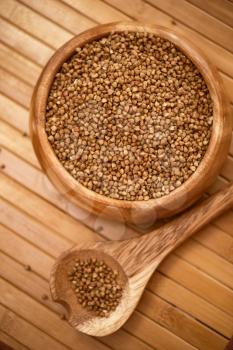 buckwheat at wooden plate on wooden background