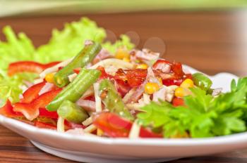 Salad from ham, tomato, green beans, corn and greens