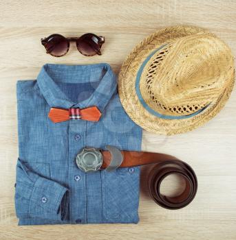 Top view collection of summer male clothing on the wooden background