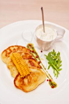 corn pancakes with cream at plate