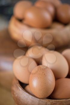 Fresh eggs at wooden plate closeup