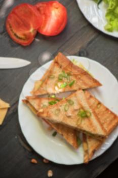 Blurred background of cheese sandwich with tomato and green lettuce
