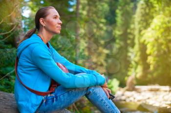 Portrait of attractive woman sitting in forest