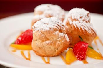 profiteroles from cream and condensed milk decorated with strawberry and peach