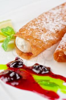 Sicilian cannoli at plate decorated with lime and jam
