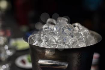 Ice bucket filled with ice cubes closeup