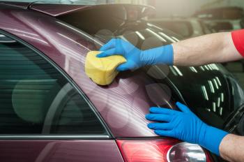 hand with sponge over the car for washing