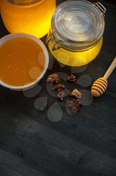 Honey with walnut on wooden background