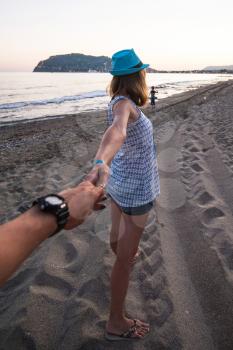 Girl holding a hand man on the beach in Alanya, Turkey