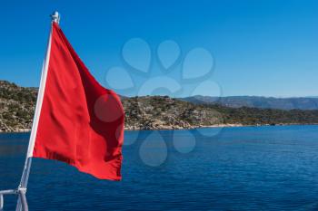 Red Flag from yacht, on sea background
