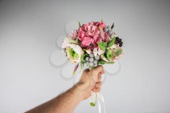 male hand giving wedding bouquet, first-person view