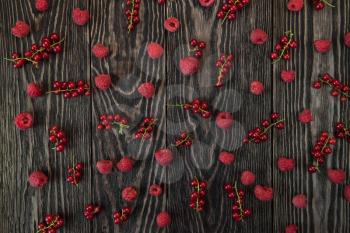 Fresh berries raspberry and red currant on wooden table for pattern