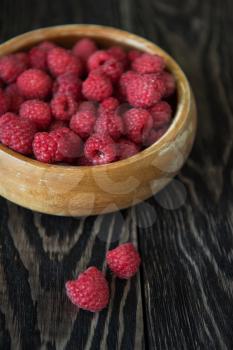 Fresh ripe raspberry on a wooden plate