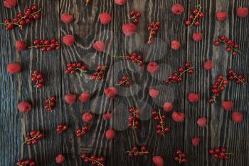 Fresh berries raspberry and red currant on wooden table for pattern